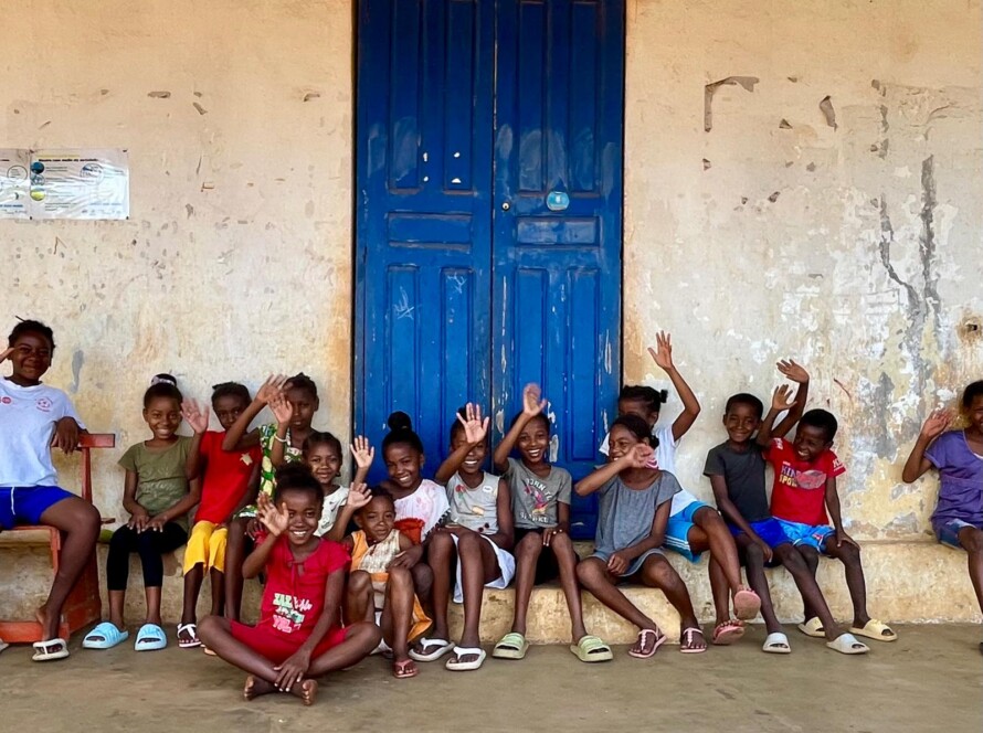 Children waving infront of blue door School in Madagascar