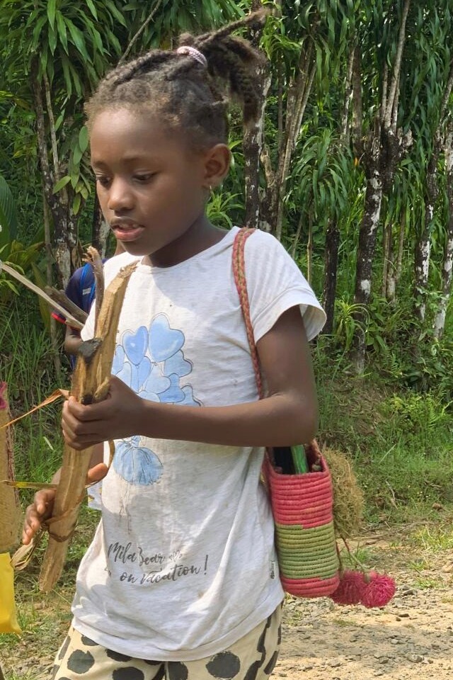 A girl carrying a piece of firewood for the canteen Madagascar east coast