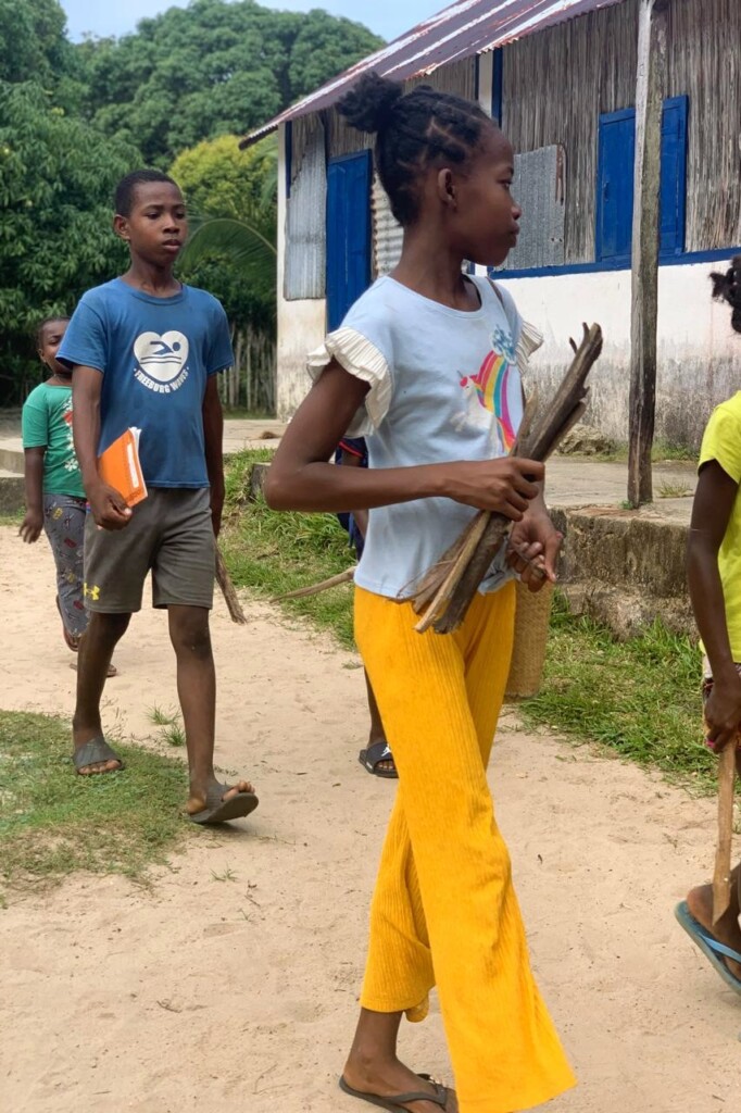 School children carrying a piece of firewood for the canteen Madagascar East Coast
